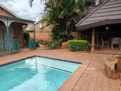 a swimming pool in front of a house at B&O's Place in Pretoria