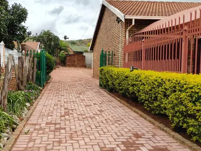 a brick path in front of a house with a fence at B&O's Place in Pretoria