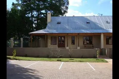a house with a gambrel roof and a parking lot at Fairstream 1 in Dullstroom