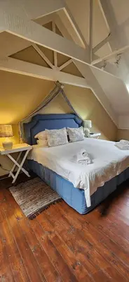 a large bed in a room with aamed ceilings at Fairstream 1 in Dullstroom