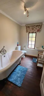 a bathroom with a tub and a toilet and a sink at Fairstream 1 in Dullstroom