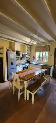 a kitchen with a wooden table and two benches at Fairstream 1 in Dullstroom