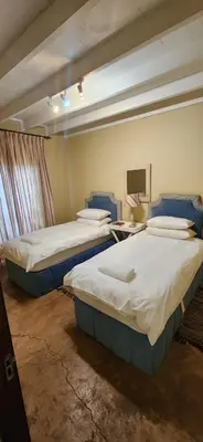 a room with two beds and a table with a tv at Fairstream 1 in Dullstroom