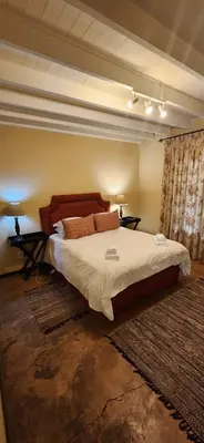 a bedroom with a large bed and two night stands at Fairstream 1 in Dullstroom