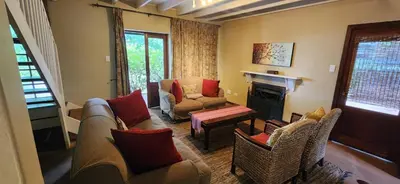 a living room with a couch and chairs and a fireplace at Fairstream 1 in Dullstroom