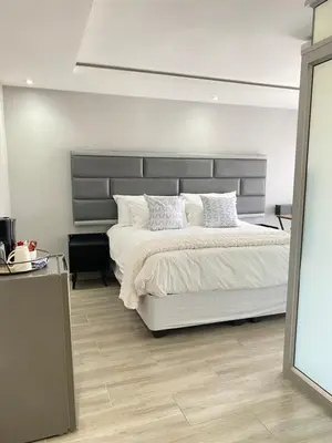 a bedroom with a large bed with white sheets and pillows at THABAKGOLO GUEST HOUSE in Ga-Manapane