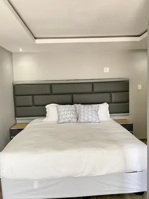a bedroom with a large white bed with two pillows at THABAKGOLO GUEST HOUSE in Ga-Manapane