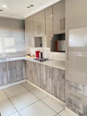 a kitchen with stainless steel cabinets and white appliances at THABAKGOLO GUEST HOUSE in Ga-Manapane