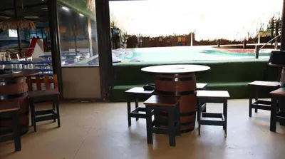 a restaurant with tables and chairs in front of a pool at LAKE-HOUSE CABIN in Witbank