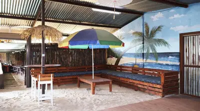 a bench with a colorful umbrella in a restaurant at LAKE-HOUSE CABIN in Witbank