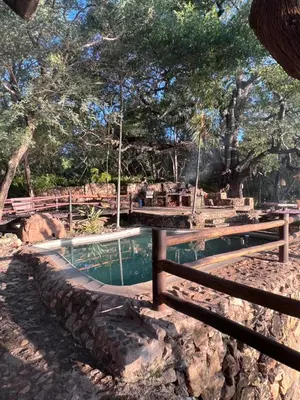 a swimming pool with a fence around it at JakkalsDraai River Bush Lodge in Hoedspruit