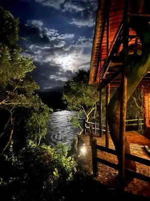 a view of a river at night with a house at JakkalsDraai River Bush Lodge in Hoedspruit
