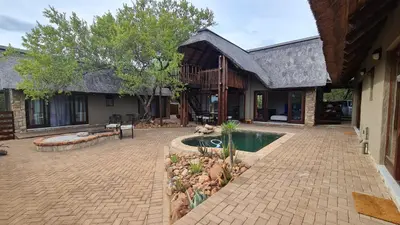 a house with a swimming pool in a yard at Hoedspruit Bush Stay in Hoedspruit