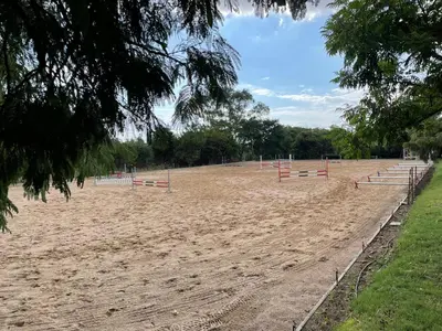 a horse race track with red poles on a field at Country living in the City in Midrand