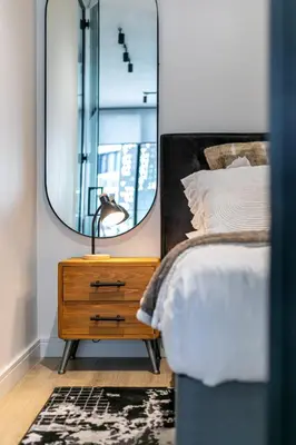 a bedroom with a mirror and a bed and a nightstand at Basia @Ellipse Waterfall in Midrand