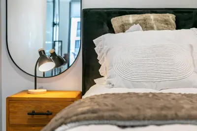 a bedroom with a bed with a mirror and a lamp at Basia @Ellipse Waterfall in Midrand