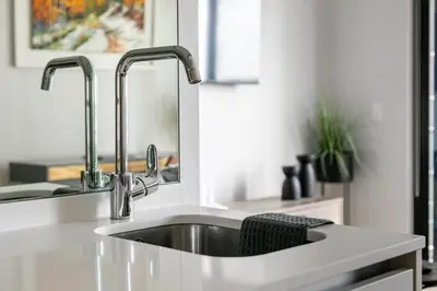 a kitchen with a sink and two faucets at Basia @Ellipse Waterfall in Midrand