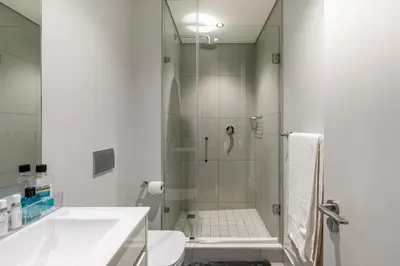 a bathroom with a shower and a toilet and a sink at Basia @Ellipse Waterfall in Midrand