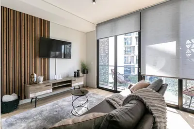 a living room with a couch and a flat screen tv at Basia @Ellipse Waterfall in Midrand