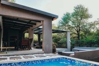 a house with a swimming pool and a patio at Chawal Stays Swartwitpens in Marloth Park