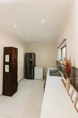 a kitchen with a sink and a refrigerator at Chawal Stays Swartwitpens in Marloth Park