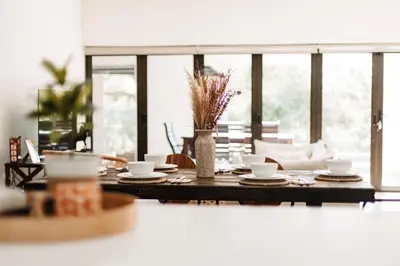 a dining room table with cups and plates on it at Chawal Stays Swartwitpens in Marloth Park