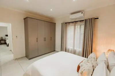 a bedroom with a large bed and a closet at Chawal Stays Swartwitpens in Marloth Park