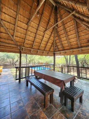 a ping pong table in a pavilion with two benches at Kudu Mal in Marloth Park