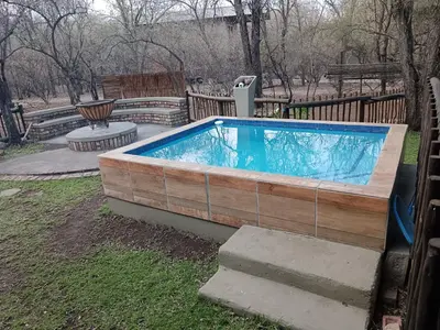 a hot tub in a yard next to a fence at Kudu Mal in Marloth Park