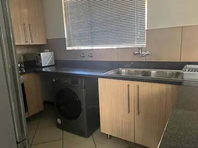 a kitchen with a sink and a washing machine at Centurion: Chilled Townhouse in Centurion