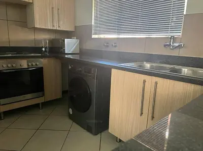 a kitchen with a black dishwasher and a sink at Centurion: Chilled Townhouse in Centurion