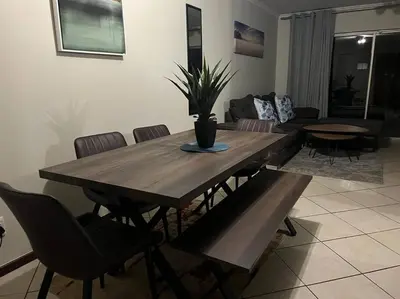 a wooden table and chairs in a living room at Centurion: Chilled Townhouse in Centurion
