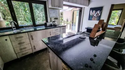 a kitchen with a counter top and some windows at Montrose River Lodge in Schoemanskloof