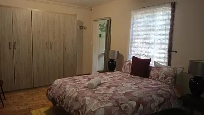 a bedroom with a large bed and a window at Montrose River Lodge in Schoemanskloof