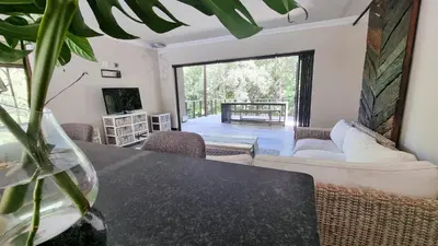 a living room with a table and a couch at Montrose River Lodge in Schoemanskloof