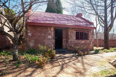 a small brick house with a red roof at Duckling Cottage in Dullstroom