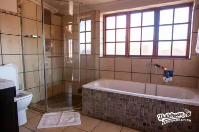 a bathroom with a tub and a shower and a toilet at Duckling Cottage in Dullstroom