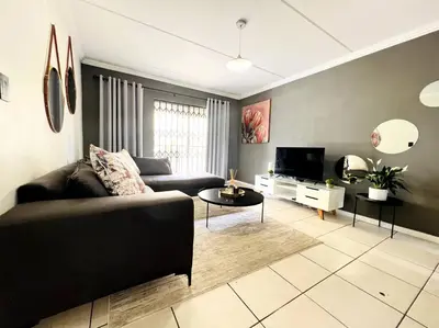 a living room with a couch and a tv at 15min to OR TAMBO perfect long stay WiFi & Netflix in Benoni