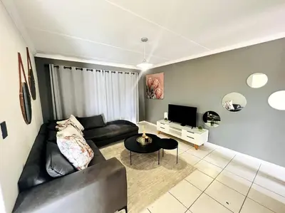 a living room with a black couch and a tv at 15min to OR TAMBO perfect long stay WiFi & Netflix in Benoni