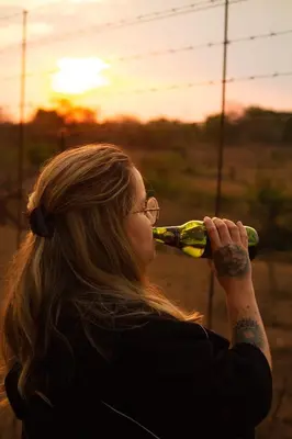 a woman drinking a bottle of wine at Kruger Park Hostel in Marloth Park