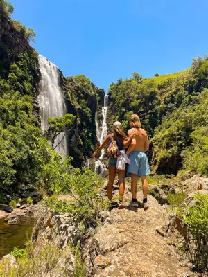 two people standing on a rock in front of a waterfall at Kruger Park Hostel in Marloth Park