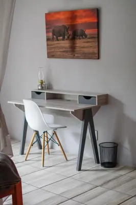 a desk in a room with two elephants on the wall at Kruger Park Hostel in Marloth Park