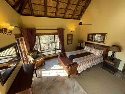 a bedroom with a bed and a couch at Lodge on Watering Hole , Zebula in Mabula