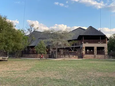 a large brick building with a person standing in front of it at Lodge on Watering Hole , Zebula in Mabula