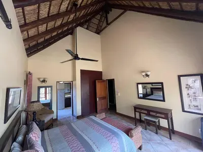 a bedroom with a bed and a desk in a room at Lodge on Watering Hole , Zebula in Mabula