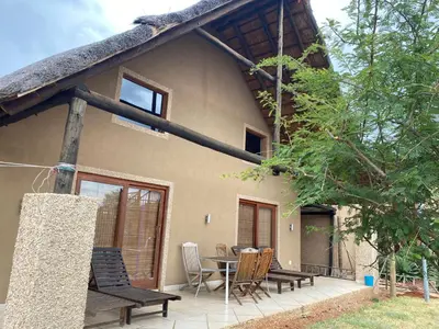a house with a patio and a table and chairs at Luna Piena 19A Zebula golf course and spa resort in Mabula