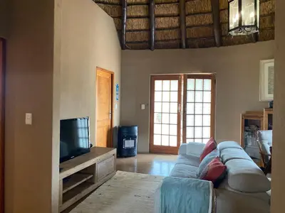 a living room with a couch and a tv at Luna Piena 19A Zebula golf course and spa resort in Mabula