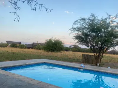 a swimming pool in a yard with a tree at Luna Piena 19A Zebula golf course and spa resort in Mabula