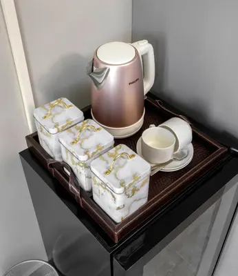 a shelf with a tea pot and cups on it at Woman Era Guest House in Midrand