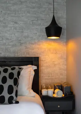 a bed with a black and white pillow and a lamp at Woman Era Guest House in Midrand